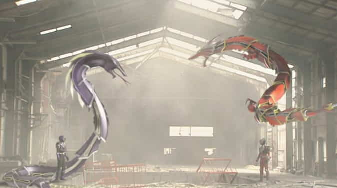A wide shot from episode 19 of Kamen Rider Ryuki. Ouja stands on the left, backed by Venosnaker towering over him, facing towards Ryuki, who stands on the right, backed by Dragreder towering over him.